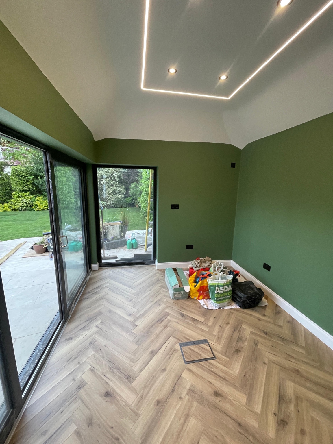 Garden room in a Liverpool home decorated by Fresh Finish Decor in deep olive green with crisp white ceiling and skirting